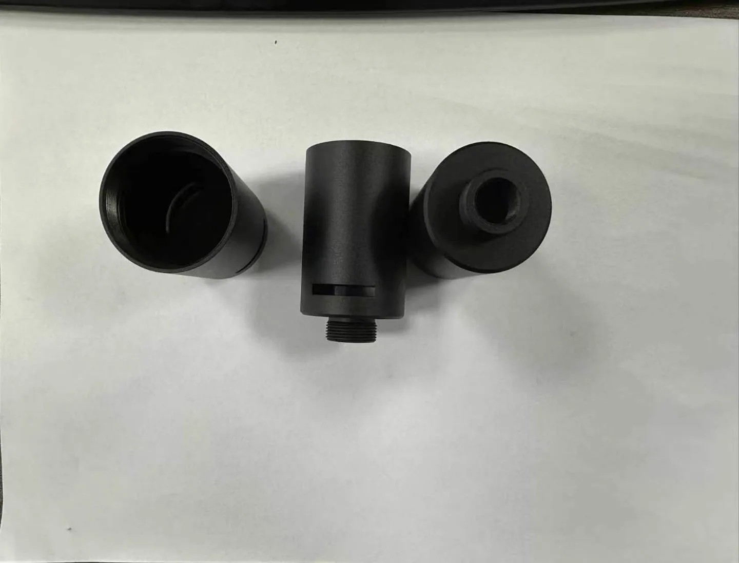 Dark cylindrical components with threaded and recessed features