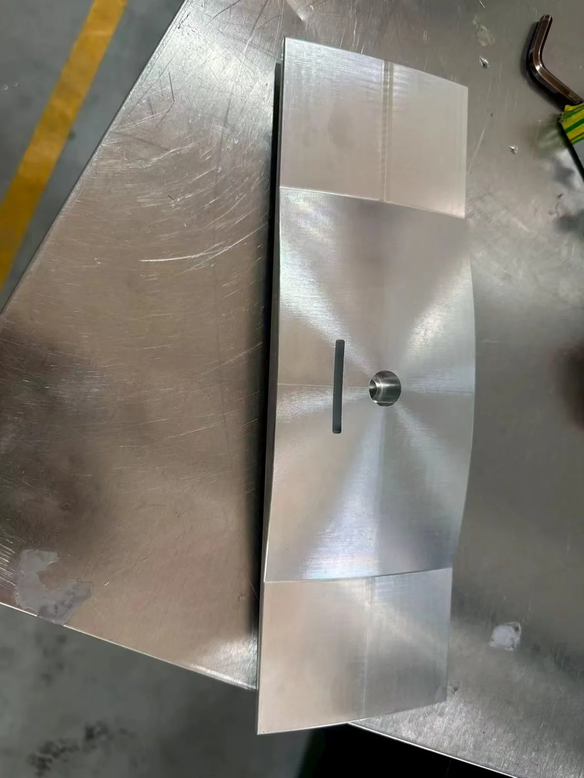 Custom curved component with a circular opening and narrow slot