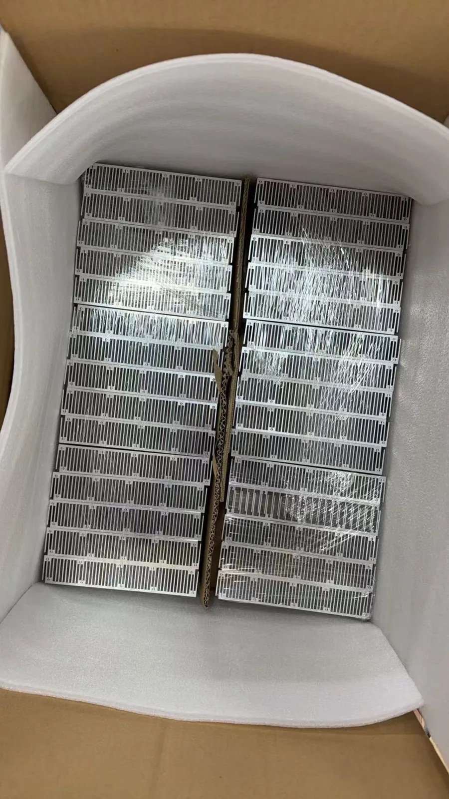 Packaged batch of custom heat-sink components protected with foam