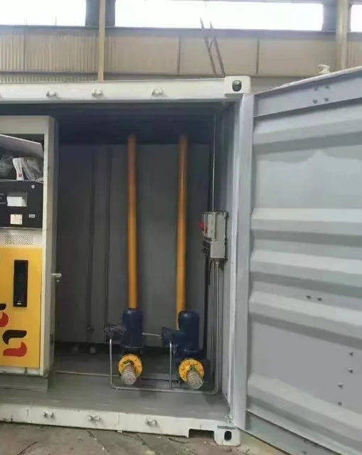 Fuel dispenser, two pumps and vertical pipework inside a container during assembly.